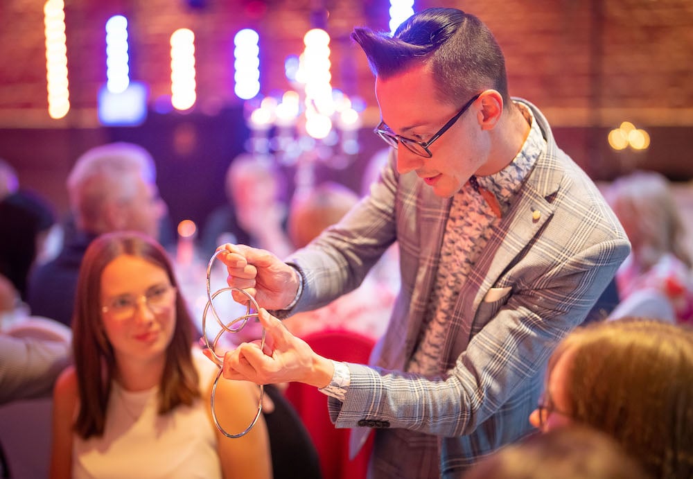 Zauberer der als Künstler zwischen den Gästen bei der Hochzeit herumläuft buchen